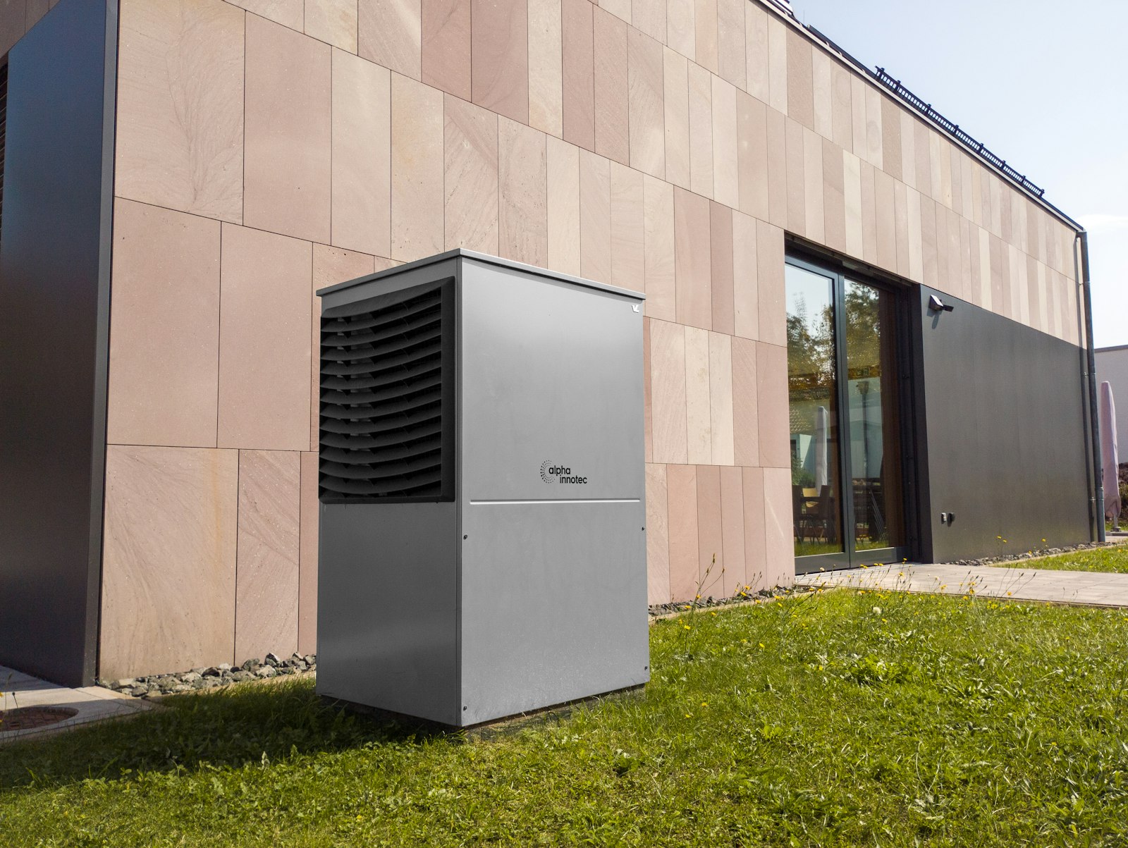Pompa di calore moderna installata sulla parete esterna di un'abitazione
