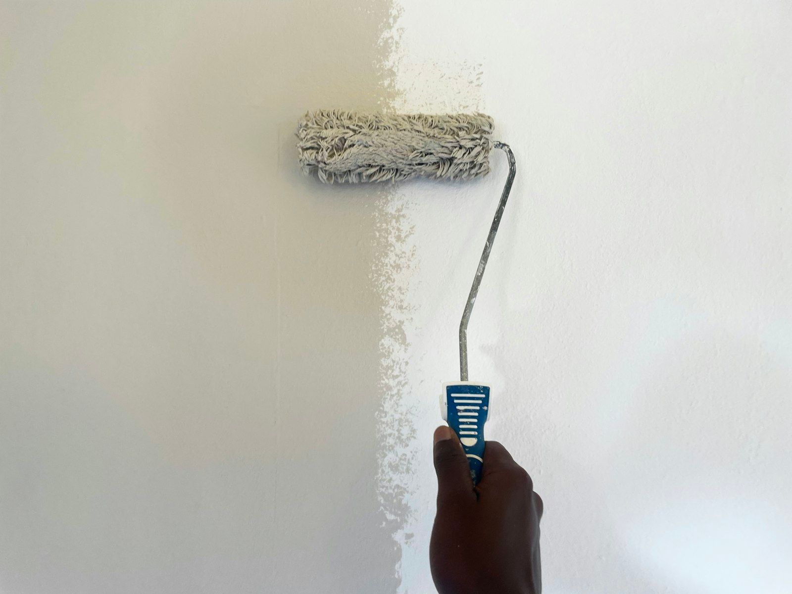 Rullo per pittura che stende il colore su una parete interna